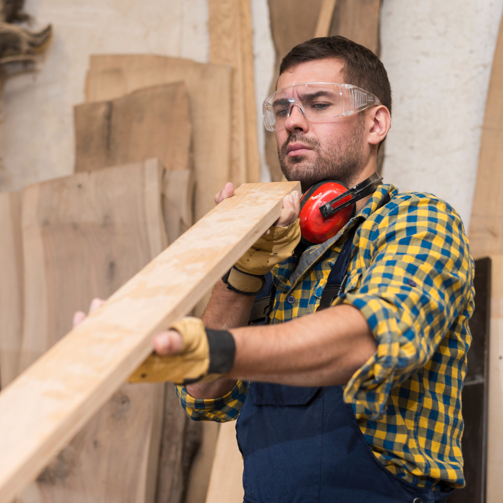 male-carpenter-seriously-looking-wooden-plank